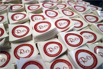 Bunker af runde røde logo-klistermærker til Rosemary & Co